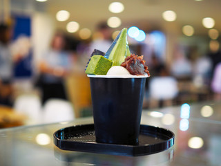 Two Tone soft serve ice cream, green tea and charcoal served in black cup decorated with mochi ball, chocolate and red bean, Traditional Japanese confectionery, Healthy concept.