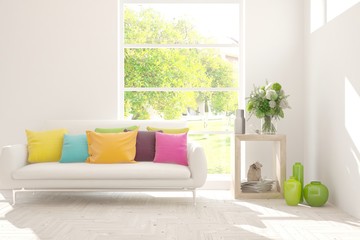 Obraz premium Stylish room in white color with sofa and summer landscape in window. Scandinavian interior design. 3D illustration