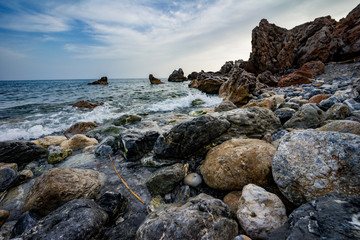 High rocky coast and sea waves of the Mediterranean sea.