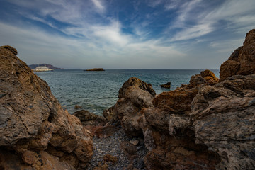 High rocky coast and sea waves of the Mediterranean sea.