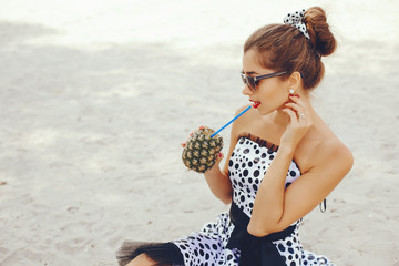 Beautiful girl with a pineapple. Lady in a retro dress. Woman in a sunglasses