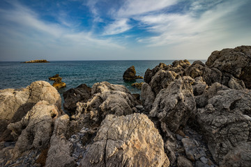 Fototapeta na wymiar High rocky coast and sea waves of the Mediterranean sea.