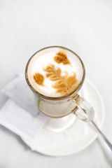 Iced coffee cappuccino latte art with condiment on a table