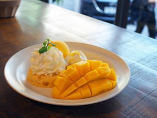 Beautiful tasty ripe mango with ice cream, pudding and sticky rice on a white plate.