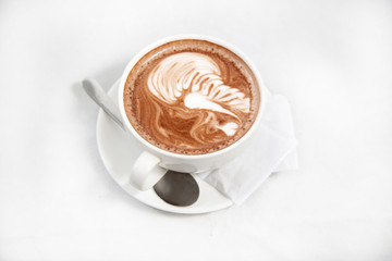 Hot cappuccino latte art coffee on the table. Morning breakfast with coffee steamed milk.