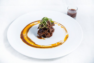 Beef fillet in black pepper sauce on a white plate. Asian cuisine dish.