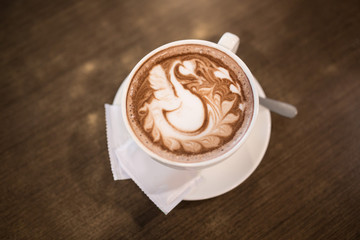 Hot cappuccino latte art coffee on the table. Morning breakfast with coffee steamed milk.