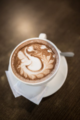 Hot cappuccino latte art coffee on the table. Morning breakfast with coffee steamed milk.