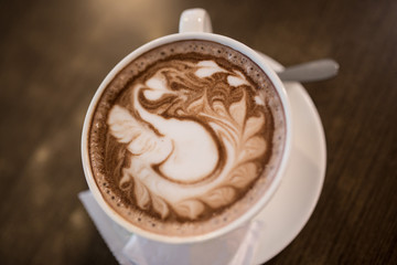 Hot cappuccino latte art coffee on the table. Morning breakfast with coffee steamed milk.