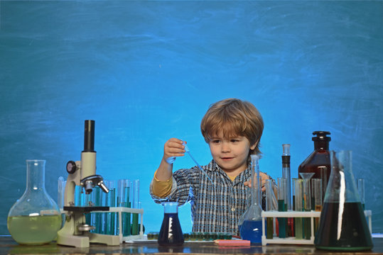 Happy smiling pupil drawing at the desk. Biology experiments with microscope. It was a little chemistry experiment. Little kid scientist earning chemistry in school lab.