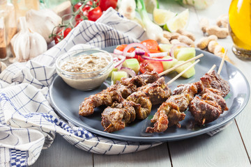 Traditional pork satay with peanut sauce and vegetables