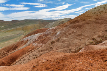 Red mountains in Kyzyl-Chin valley in Altay. Scenic landscape with clouds. Close up. Summer concept.