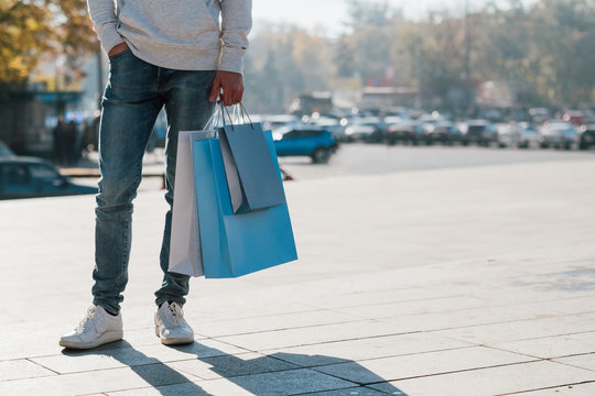 Shopaholic Lifestyle. Cropped Shot Of Man In Casual Outfit Standing With Packages. Fall Urban Street Background. Copy Space.