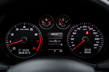 Fototapeta premium Interior view of car with black salon. Modern luxury prestige car interior: speedometer, dashboard and tachometer with white backlight and other buttons. Soft focus