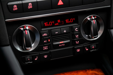 Black detail with the air conditioning button, the dashboard with information about temperature...