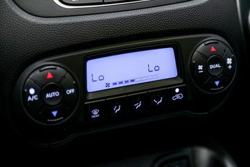 Black detail with the air conditioning button, the dashboard with information about temperature inside a car. Close up car ventilation system and air conditioning - 