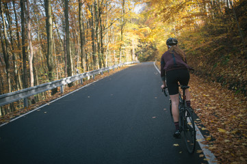 Autumn bike ride with climbing up in the valley covered with golden leaves