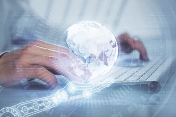 Double exposure of world map hologram with man working on computer on background. Concept of worldwideweb.