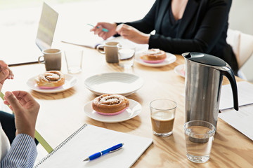 People in a meeting with cinnamon buns on the table