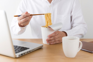 カップラーメンを食べる男性