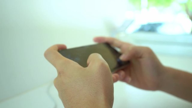 Men are playing games on mobile phone that have Casual Office. Play games in the library.