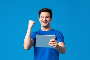 Excited man holding tablet computer