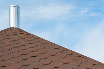 Chimney pipe from stainless steel on the roof of the house.