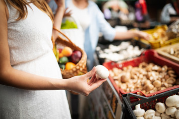 Young happy women shopping vegetables and fruits on the market