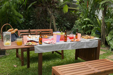 settle wooden table outdoor and red plate with beers for food and prepare for barbecue camping party together in nature