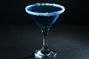 A glass with blue martini cocktail	