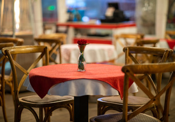Close up of the centerpiece of a spanish restaurant table with red checkered tablecloth and wood chairs