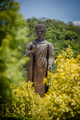 big black buddha image stand in garden