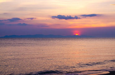 The beach overlooking the sunset behind the mountain.