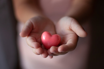 child hands holding heart, health insurance, charity concert donations. Health care, love and family concept, world heart day
