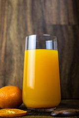 still life photo of orange juice, orange smoothie in glass on wooden background.