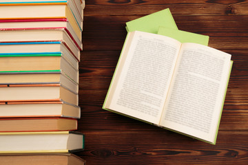  learning concept with opening book or textbook in old library, stack piles of literature text academic archive on reading desk and aisle of bookshelves in school study class room background - Image