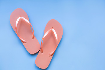 Living coral flip flops on a blue background. Color of the year 2019. Living coral. Place for text.