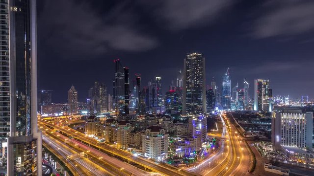 Aerial view to downtown and financial district in Dubai during all night timelapse, lights swithing off. United Arab Emirates with illuminated skyscrapers and highways.