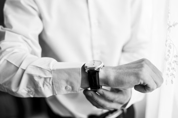 businessman checking time on his wrist watch, man putting clock on hand
