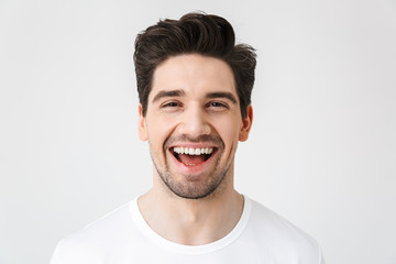 Happy young excited emotional man posing isolated over white wall background.