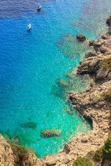 Mediterranean sea with alone boats on blue water, Capri island, Italy.