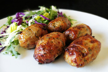 Grilled Sausages with Fresh Vegetables on a White Plate. Traditional Cypriot food: Sheftalia : Cypriot Lamb and Pork Sausages.   