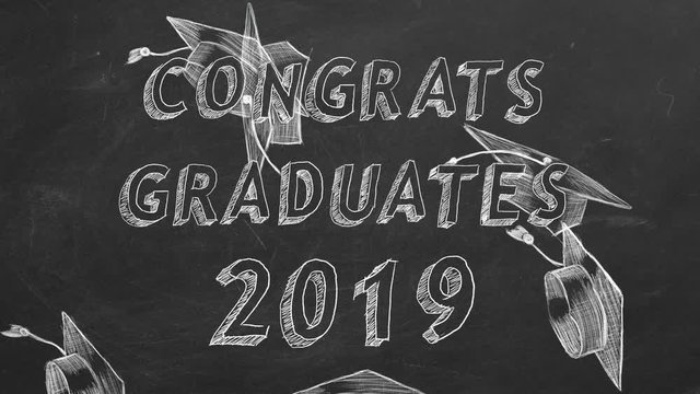 Hand drawing text "Congrats graduates. 2019." and graduation caps on blackboard.
