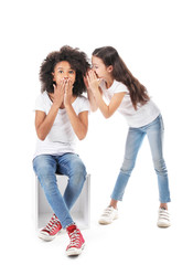 Gossiping girls in jeans on white background