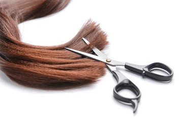 Hair strand and scissors on white background