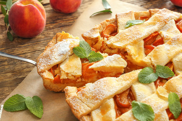 Tasty peach pie on wooden background, closeup