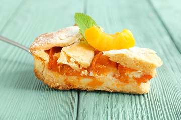 Piece of tasty peach pie on wooden background, closeup