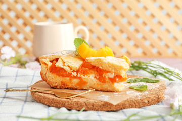 Piece of tasty peach pie on table