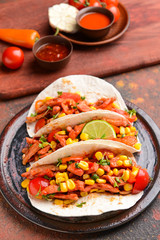 Plate with tasty tacos on grunge background