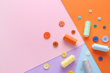 Set of sewing threads and buttons on color background
